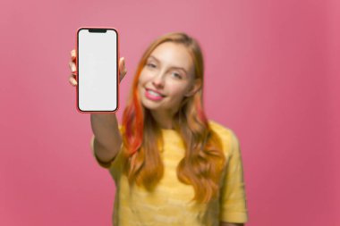 Gülümseyen kızın elindeki akıllı telefonu kapat. Boş ekran telefonunu taklit et. Mobil uygulamalar ve servis reklamları