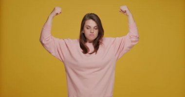 Kız gücü. Komik gülümseyen genç dişiler, kaslarını göstererek başarılarından gurur duyduklarını gösterirler.