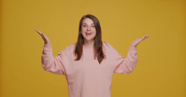 Lively positive friendly young woman blogger blow air-kisses, having fun greet, goodbye or thank on yellow background — Stock Video