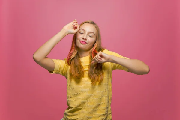 Chica joven moderna bailando, divirtiéndose, celebrando el éxito, disfrutando de la fiesta de música de fin de semana ojos cerrados sobre fondo rosa — Foto de Stock