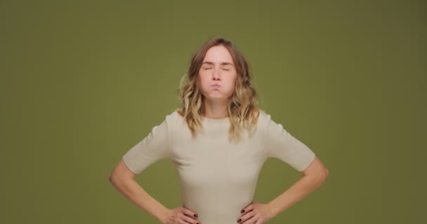 Comic young woman show tongue making faces squinting eyes having fun, teasing, fooling on green studio background — Vídeo de Stock