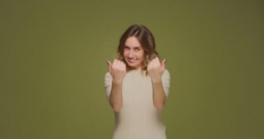 Gülümseyen, dost canlısı genç bir kadın, elleri ile çağırır, yeşil stüdyo geçmişi hakkında konuşmaya davet eder.