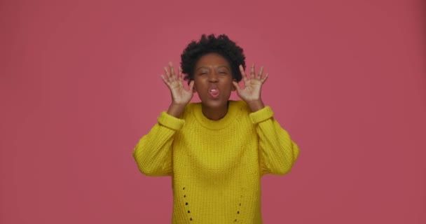 Playful african american young woman show funny faces gesturing, grimace with tongue and hands, teasing, having fun — Video Stock