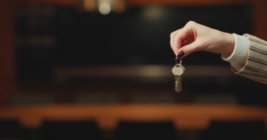 Welcome to new house. Close up of female hand hold keys of apartment. Real estate agent realtor give key from home flat