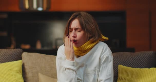 Sick upset young woman coughing, freezing, having fever, sitting on couch at home. Seasonal flu or influenza symptoms — Videoclip de stoc