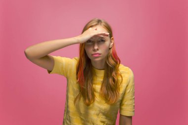 Attentive young girl keep palm over head, looking far away, peering at camera, searching. Quest and discovety concept