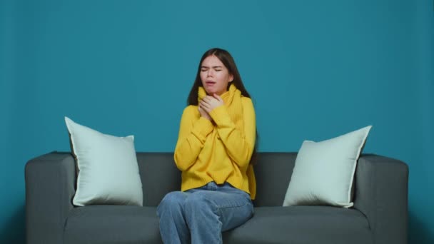Sick young girl cough, feeling unhealthy, suffering from respiratory disease, flu, cold or bronchitis, sitting on couch — Stock video