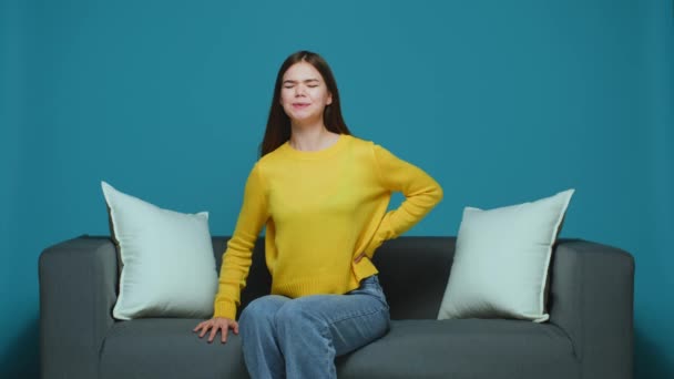 Sick young girl feel pain rubbing lower back spine grimacing suffer lumbar backache after sitting in incorrect posture — Vídeo de Stock