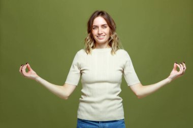 Happy calm healthy young woman show mudra gesture practicing yoga exercise, meditating, breathing. Stress relief concept