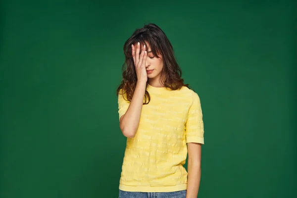 Facepalm gesture. Stressed tired young girl cover face by hand feel sorrow, shame for mistake on green studio background — Stock Fotó