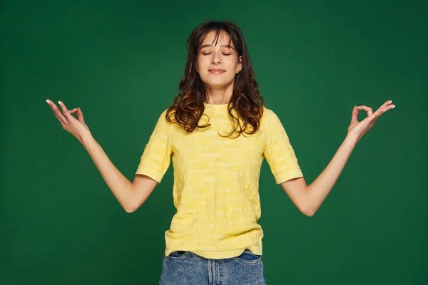 Chica joven calma extendiendo las manos en el gesto de yoga om dedos doblados en mudra, ojos cerrados. Sin estrés, estilo de vida saludable —  Fotos de Stock