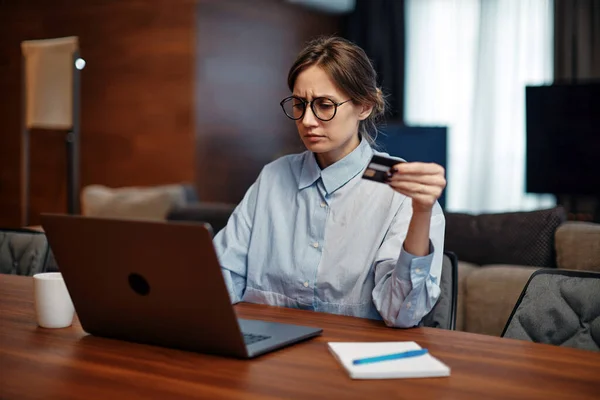 Upset young woman worker using online banking on laptop, trouble blocked credit card. Internet fraud, bankruptcy, debt — стоковое фото