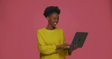 Modern yaratıcı Afrikalı Amerikalı kız dizüstü bilgisayarda çalışıyor, e-posta yazıyor, sosyal ağda sohbet ediyor.