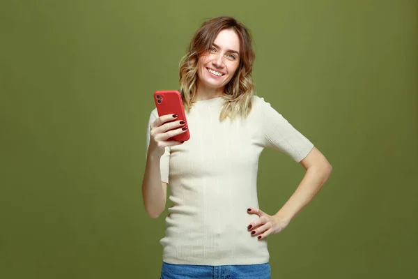 Happy optimistic young girl hold phone smiling looking at camera, satisfied with using social media or e-learning apps — Stock Photo, Image