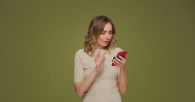 Mutlu şanslı kadın elinde telefonla iyi haber mesajı okuyor, zaferi kutluyor, dans ederek eğleniyor. Bingo, ikramiye, servet.