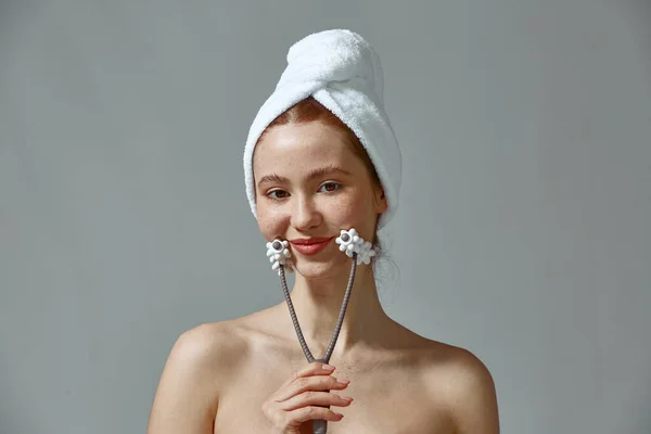 Menina jovem massageando o queixo do rosto pelo massageador facial moderno após o banheiro. rotina diária de cuidados com a pele para rejuvenescer — Fotografia de Stock