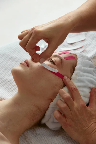 Nastro del lifting facciale. Primo piano della procedura di nastratura del viso per levigare le rughe, sollevare la pelle che stringe. Ringiovanimento, cura della pelle — Foto Stock