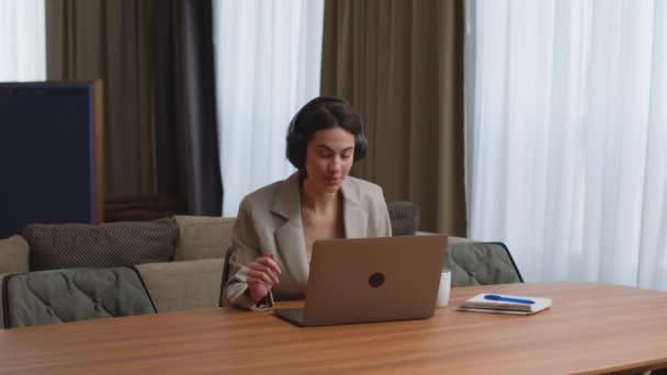 Uśmiechnięta kobieta biznesu w słuchawkach, praca na laptopie, operator call center konsultingu klienta online. Praca zdalna — Wideo stockowe