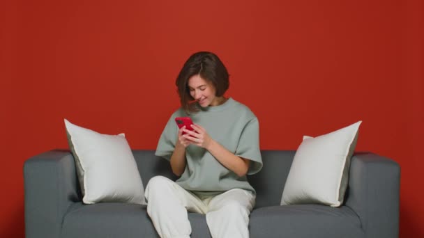 La chica está enviando mensajes de texto en su teléfono inteligente con su novio. Alégrate y ríe con felicidad. Recibe buenas noticias. Buen humor.. — Vídeo de stock