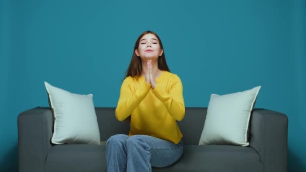 Pleitend jong meisje maken bidden of smeken gebaar vragen om gunst, steun, hulp, zitten op de bank — Stockvideo