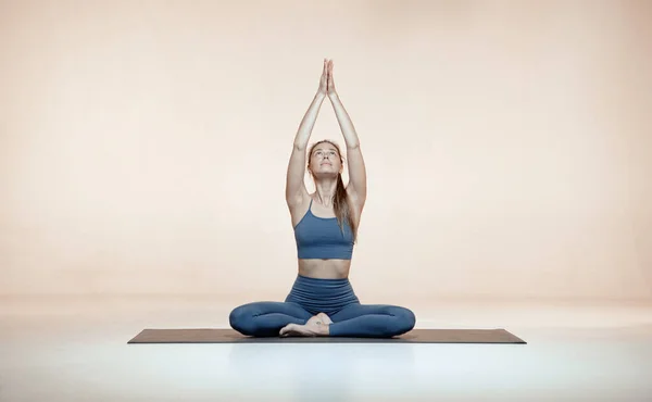 女瑜伽教练交叉腿坐着，摆出莲花姿势或帕吉萨娜让娜玛斯提手冥想 — 图库照片