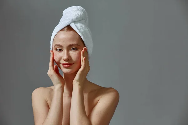 Mulher bonita em toalha toque massagem pele saudável, satisfeito com spa salão de tratamentos faciais — Fotografia de Stock