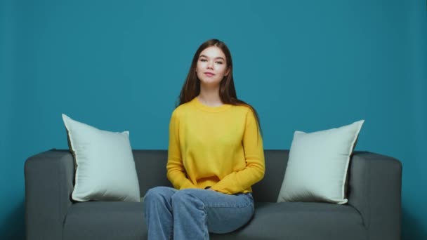 Happy young girl show ok gesture smiling looking at camera satisfied with service sitting on sofa — Stock Video