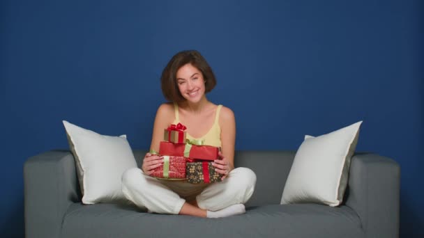 Ένα χαρούμενο γοητευτικό κορίτσι κρατάει ένα σωρό δώρα σε ένα όμορφο πακέτο. Η έννοια των γενεθλίων, Χριστούγεννα και Ημέρα του Αγίου Βαλεντίνου. — Αρχείο Βίντεο