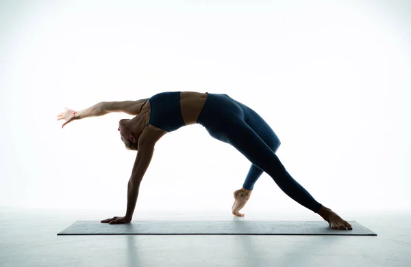 灵活的年轻适合的女孩练习瑜伽 为伸展身体 健康的白色背景表演野性瑜伽 漂亮的芭蕾舞演员在地板上训练 高质量的照片 — 图库照片