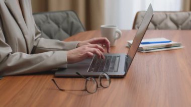 Dizüstü bilgisayarda yazı yazan kadın eller, masada çalışan bilgisayarlar. Çevrimiçi iş ya da eğitim, işyerinin kapatılması