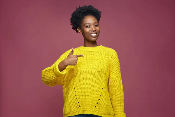 Benim. Hırslı, kendinden emin, Afro-Amerikan, dişlek, gülümseyen, pembe arka planda kendini gösteren bir kadın.