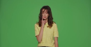 Zor işi çözen düşünceli, genç bir kız. Cevabı yok. Kromakey yeşil arka planda seçim yapamaz.