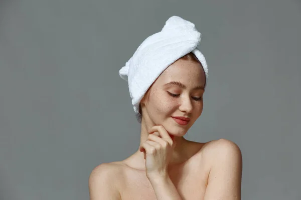 Mulher jovem com pele perfeita rosto liso, ombros nus, toalha na cabeça. Beleza natural, conceito de cuidado da pele — Fotografia de Stock