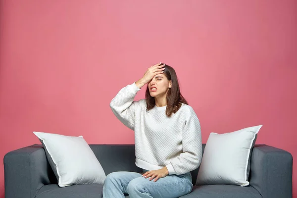 Aufgebrachte junge Mädchen machen Facepalm-Geste, geben sich selbst die Schuld, empfinden Kummer wegen schlechter Erinnerung, Fehler, sitzen auf dem Sofa — Stockfoto