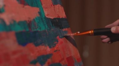 Boya fırçasıyla tuvale dokunan ressam, fırça darbeleri koyuyor. Ressam resim çiziyor, sanat eserleri üzerinde çalışıyor. ProRes