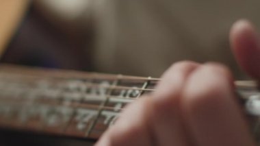 Erkek eli kapalı, akustik gitar çalarak, müzik tekniği üzerinde çalışarak. Kod çözücü. Müzik eğitimi