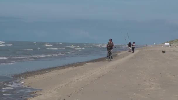 Жінка їде на велосипеді на пляжі — стокове відео