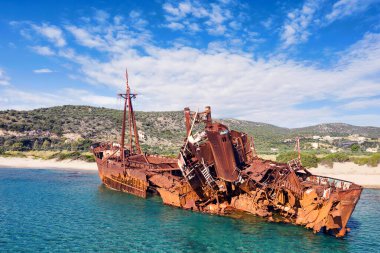 Rusty and abandoned carcass of a cargo ship on a beach in Greece following a shipwreck