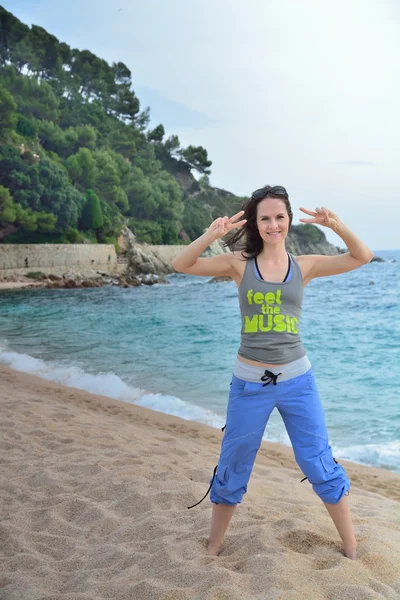 Woman doing fitness exercise on a beach — Stock Photo, Image