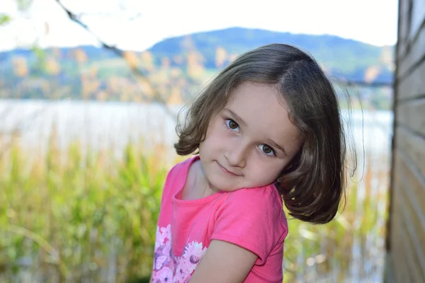 Mały dziewczyna pozuje na jeziorze — Zdjęcie stockowe