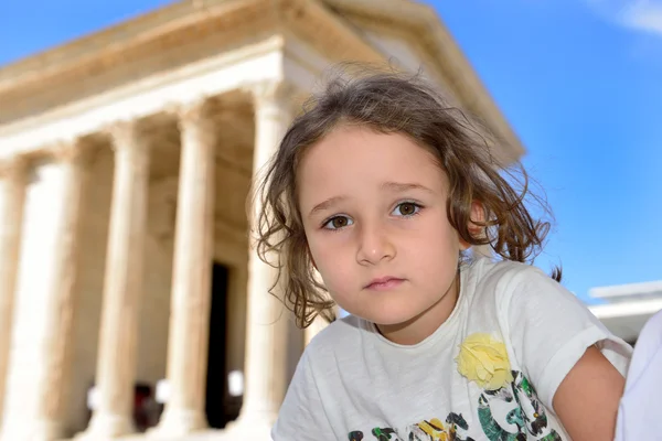 Klein meisje poseren voor een Romeinse tempel — Stockfoto