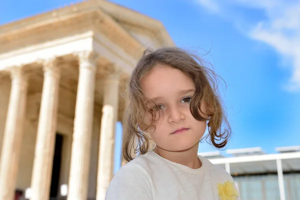 Little girl posing in front of a roman temple — Stock Photo, Image