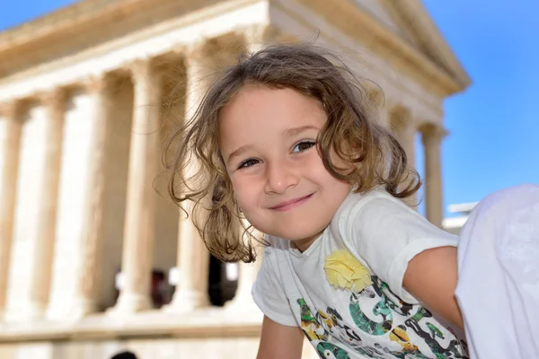 Malá dívka pózuje před římský chrám — Stock fotografie