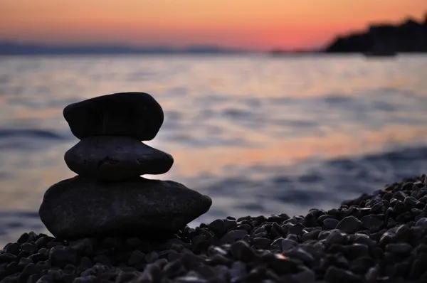 Gün batımında sahilde üç zen kayalar silüeti Stok Fotoğraf