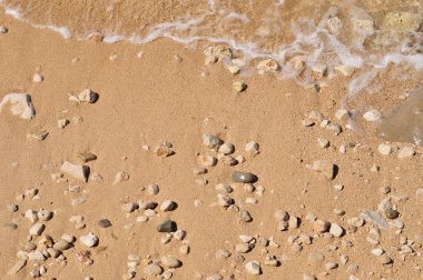 çakıl taşları ve dalga ile kumlu plaj