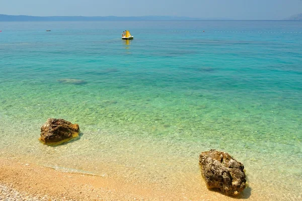 Wunderschöner Strand mit zwei großen Steinen und kristallklarem Wasser — Stockfoto