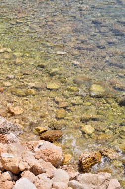 taşlar ve berrak su ile plaj