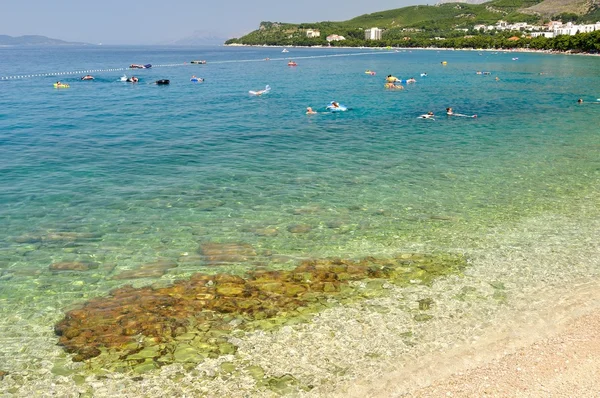 Kristal berrak Denizi ve Tucepi insanlarda ile güzel bir plaj — Stok fotoğraf