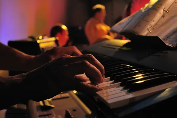 Primer plano de un par de manos tocando un piano en concierto —  Fotos de Stock