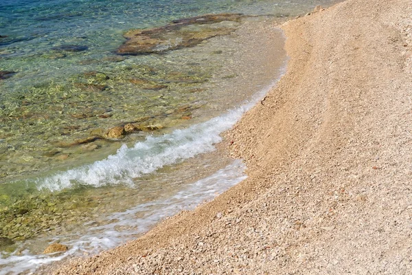 Волны на спокойном пляже с мелкой галькой — стоковое фото